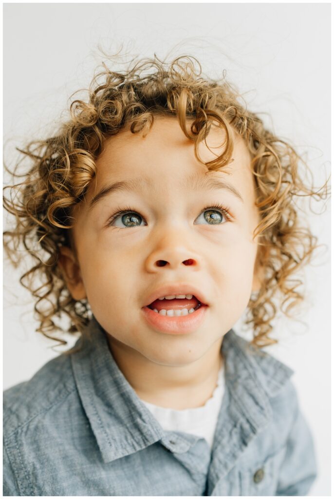 Preschool boy with curls posing for school portraits 