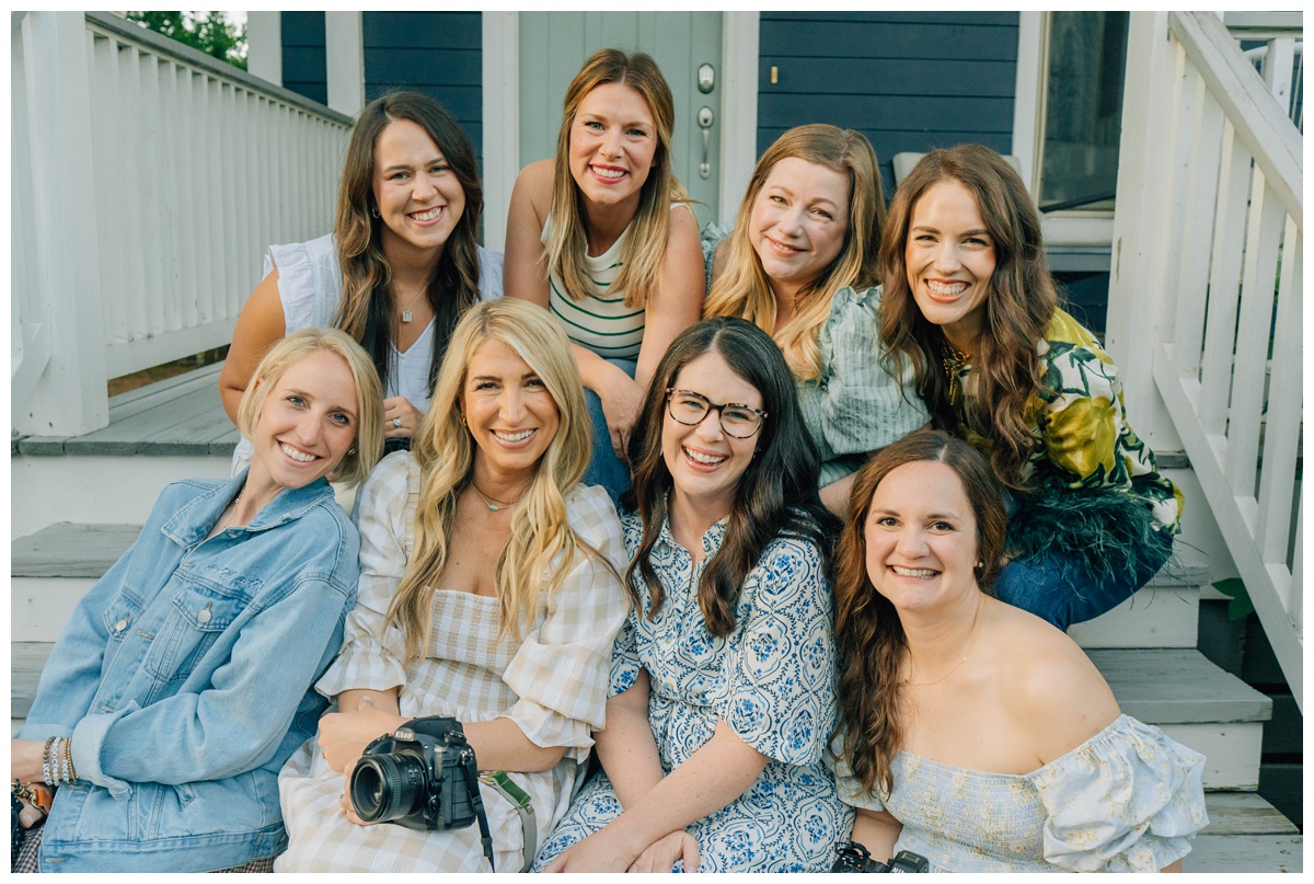 Group of photographers smiling at family photography workshop. Meet the amazing women behind the cameras—photographers from all over gathered to learn and laugh together.