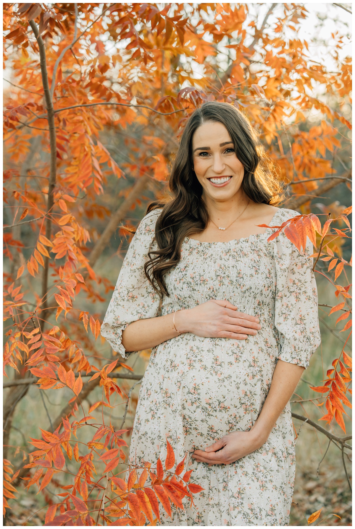 mom to be surrounded by bright fall foliage in maternity session 