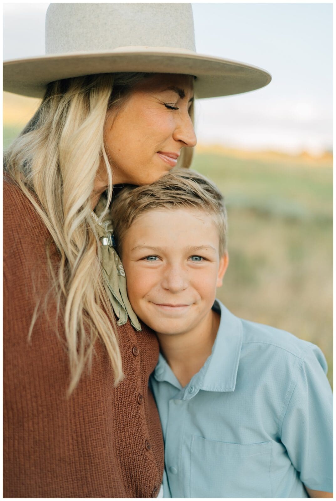 Tender family pose of a mother hugging her young son, both smiling softly during a Haley Kinzie Photography family session.