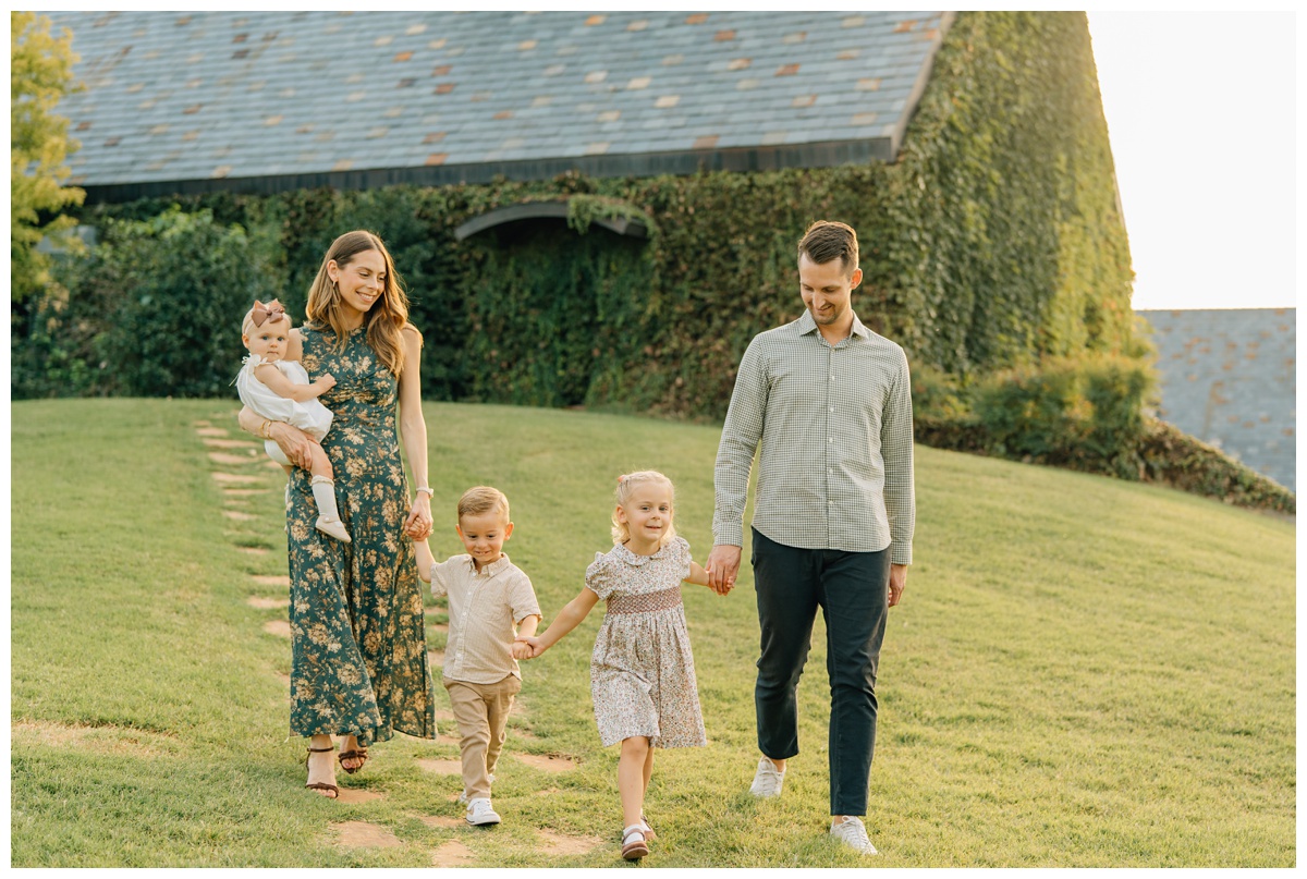 Parents walking with children on cobblstone holding hands with Oklahoma family photographer session Haley Kinzie.