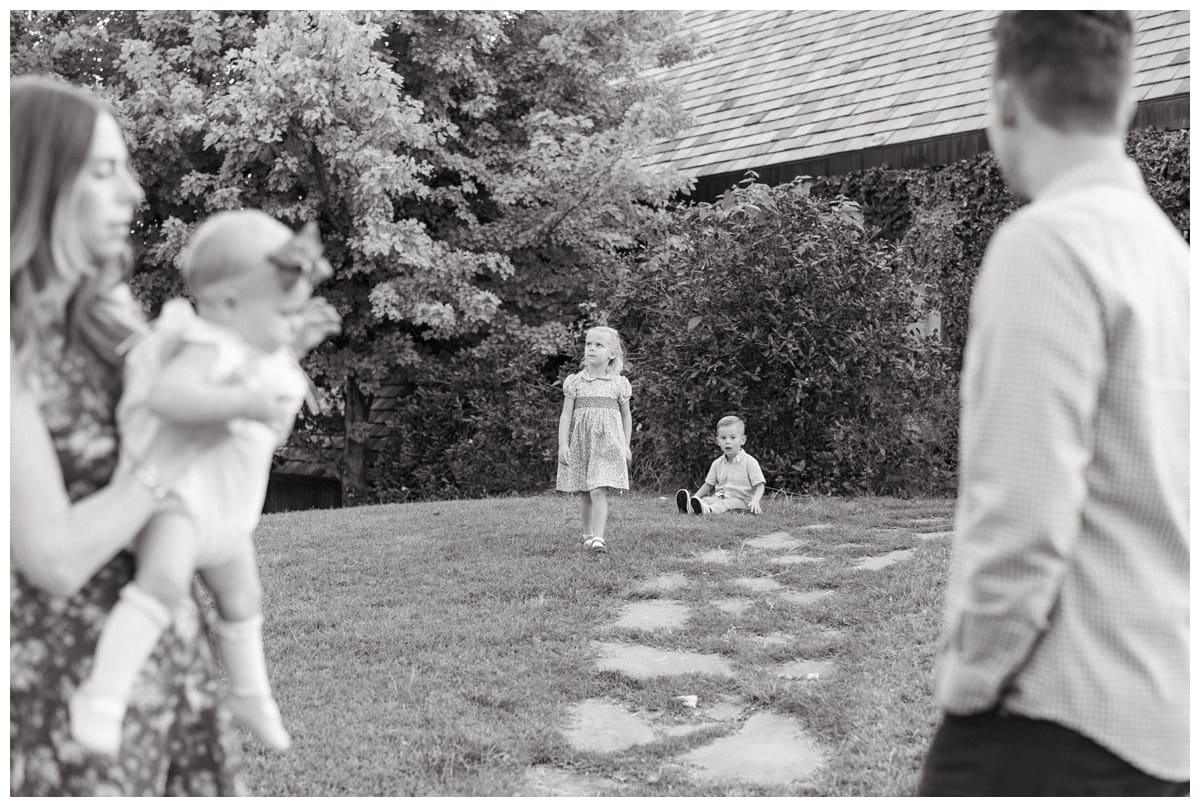 Family gathered on cobblestone path with greenery behind them — A cozy Oklahoma family portrait that celebrates togetherness.